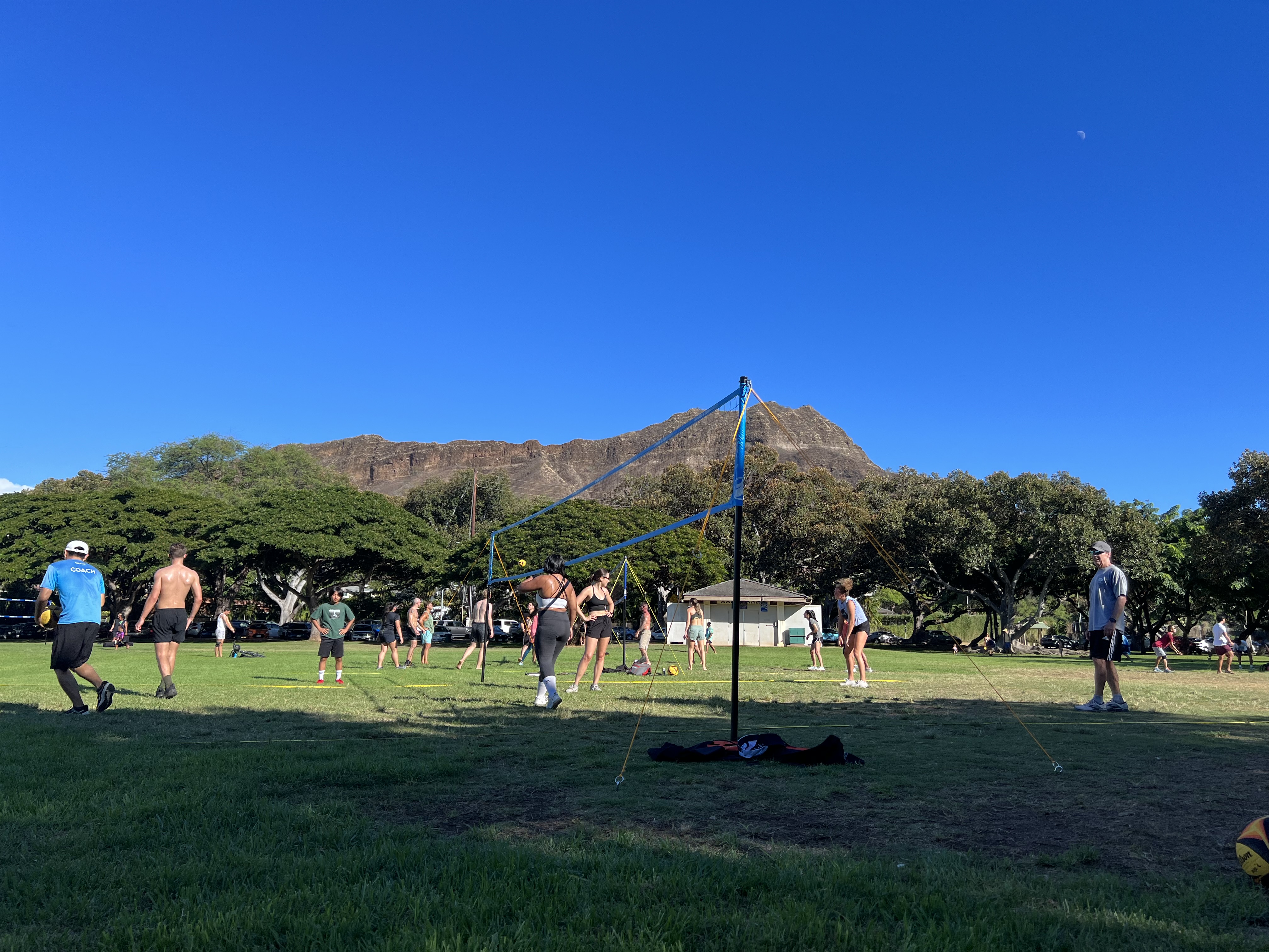 Volleyball courts at Kapiolani Park with Diamond Head in the background on a clear blue day