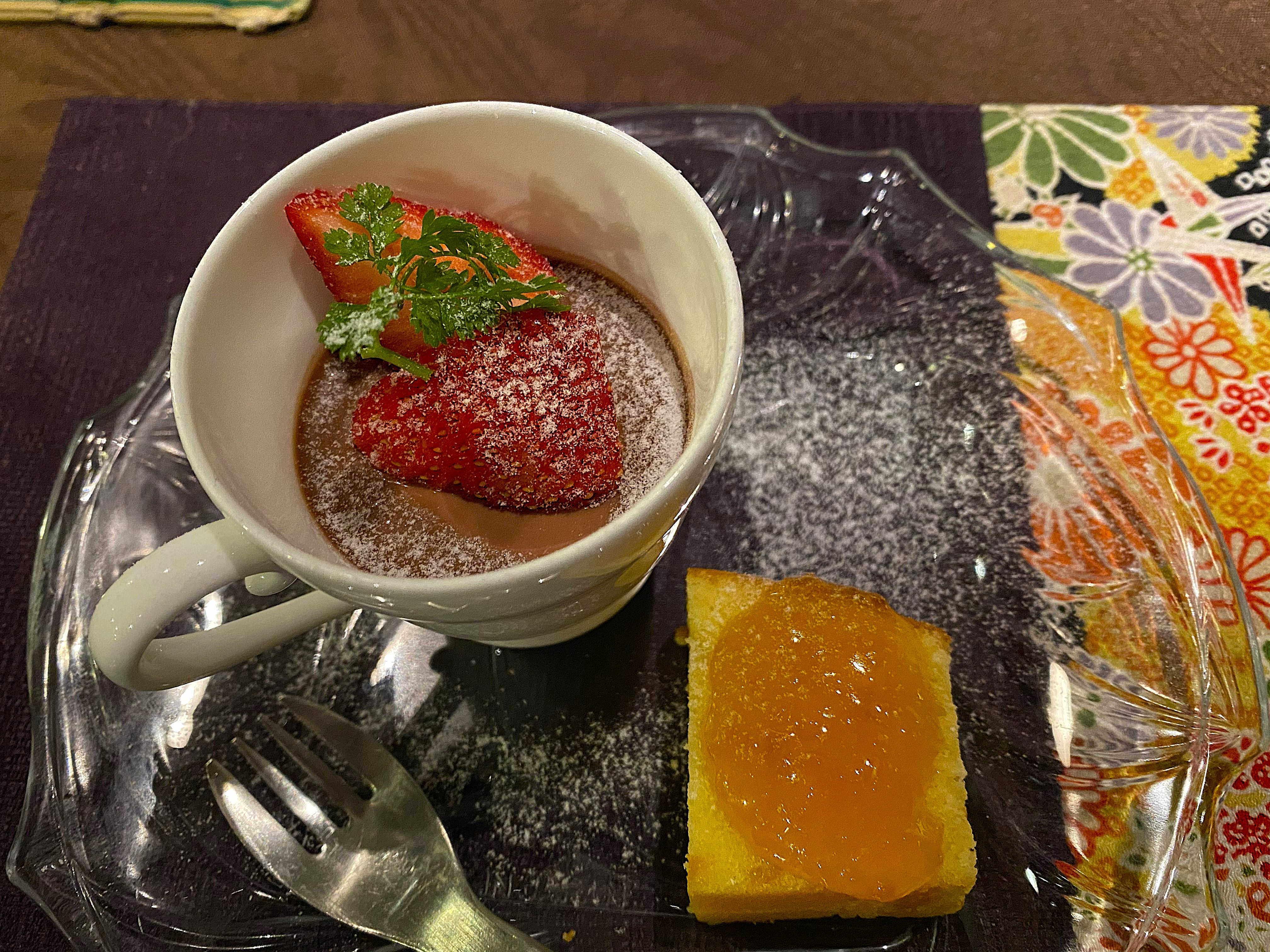 Dessert course at Satonoyu Waraku — a white cup with chocolate mousse topped with fresh Amaou strawberries and mint, powdered sugar dusted over, beside a slice of Shiranuhi citrus pound cake with marmalade glaze on a glass plate