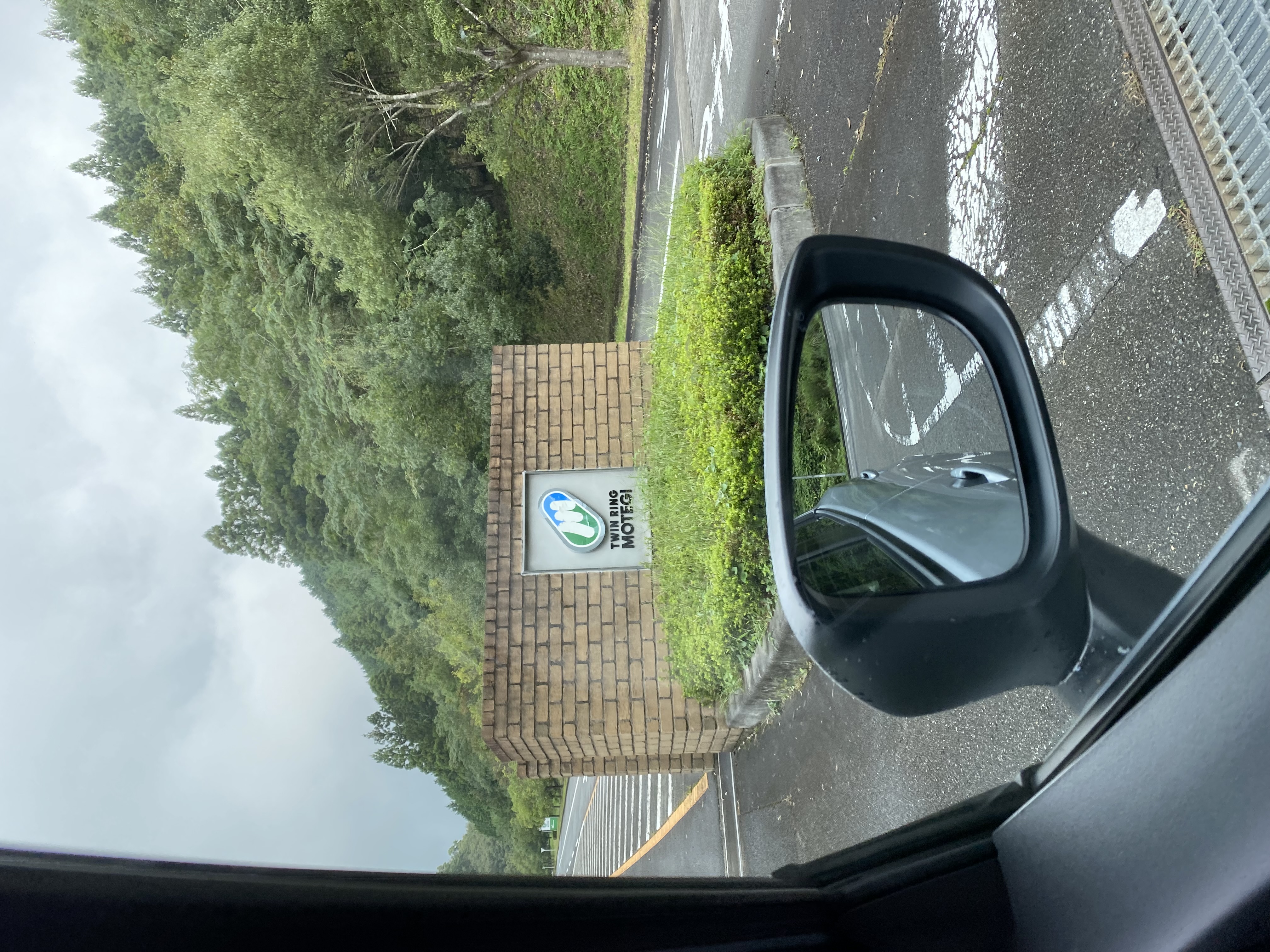 Twin Ring Motegi entrance sign seen from the car window mirror on approach