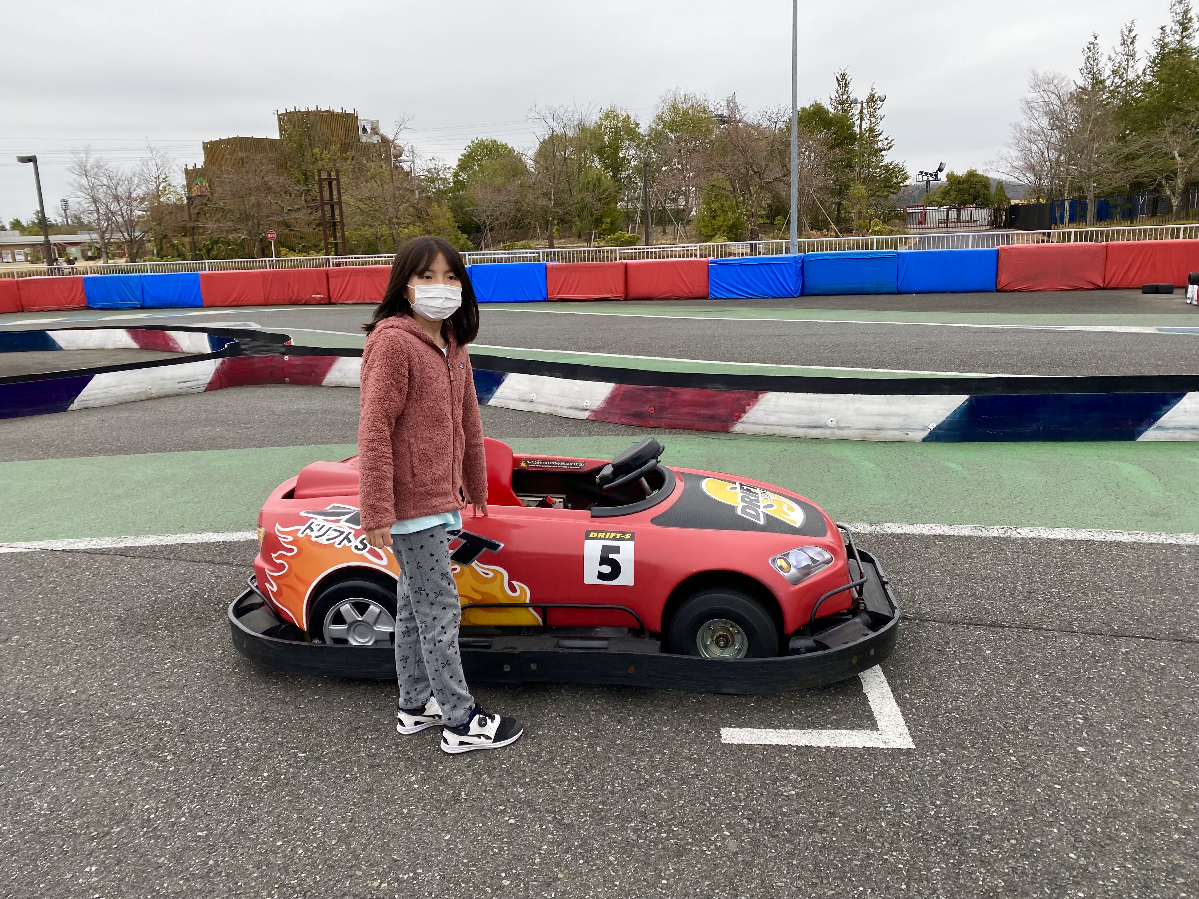 Maile standing proudly next to her red Drift-S cart number 5 at the Motegi cart racing track
