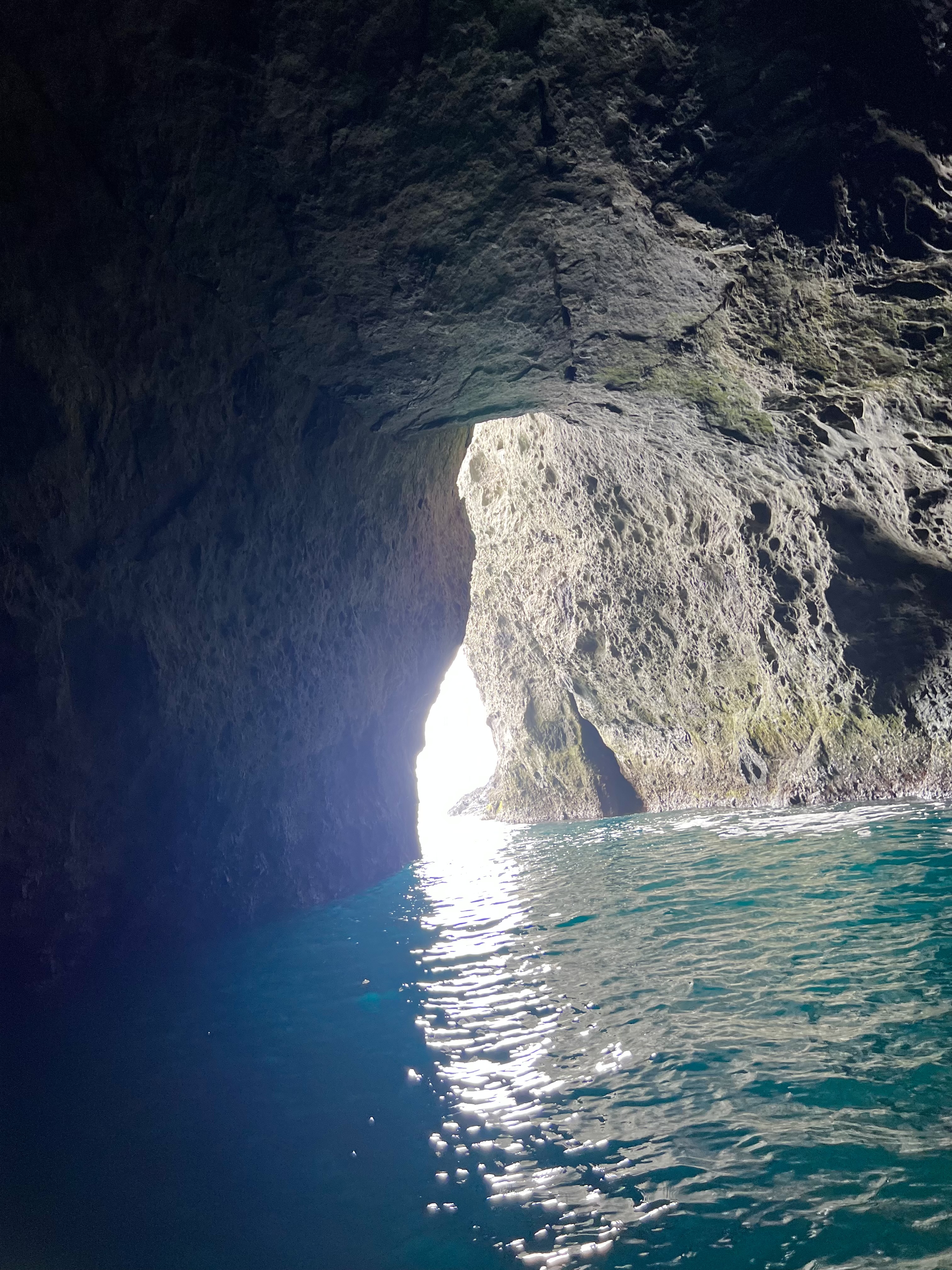 Inside Otaru's Blue Cave — light pouring through the rock arch, teal water reflecting off the cave ceiling